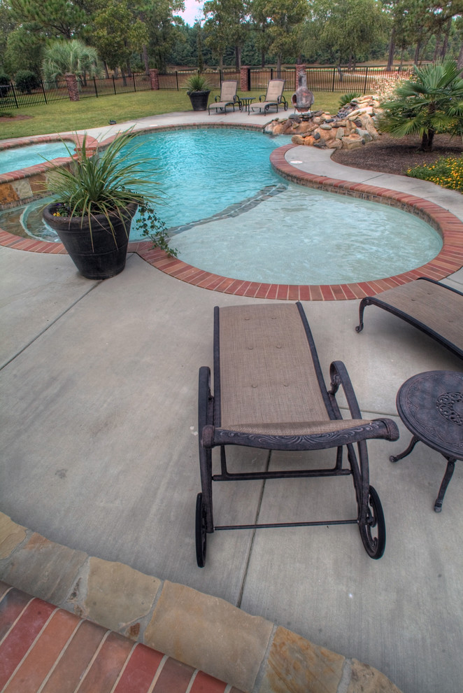Large backyard stone and custom-shaped natural hot tub photo