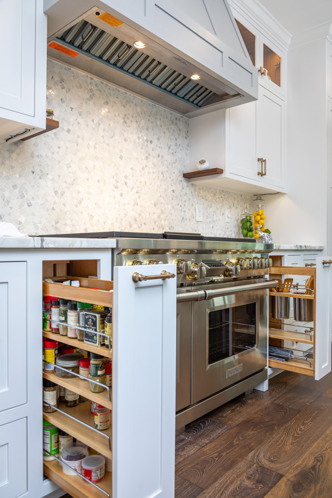 Medium sized traditional single-wall open plan kitchen in Raleigh with a single-bowl sink, shaker cabinets, white cabinets, quartz worktops, grey splashback, mosaic tiled splashback, integrated appliances, medium hardwood flooring, an island, brown floors, multicoloured worktops and exposed beams.