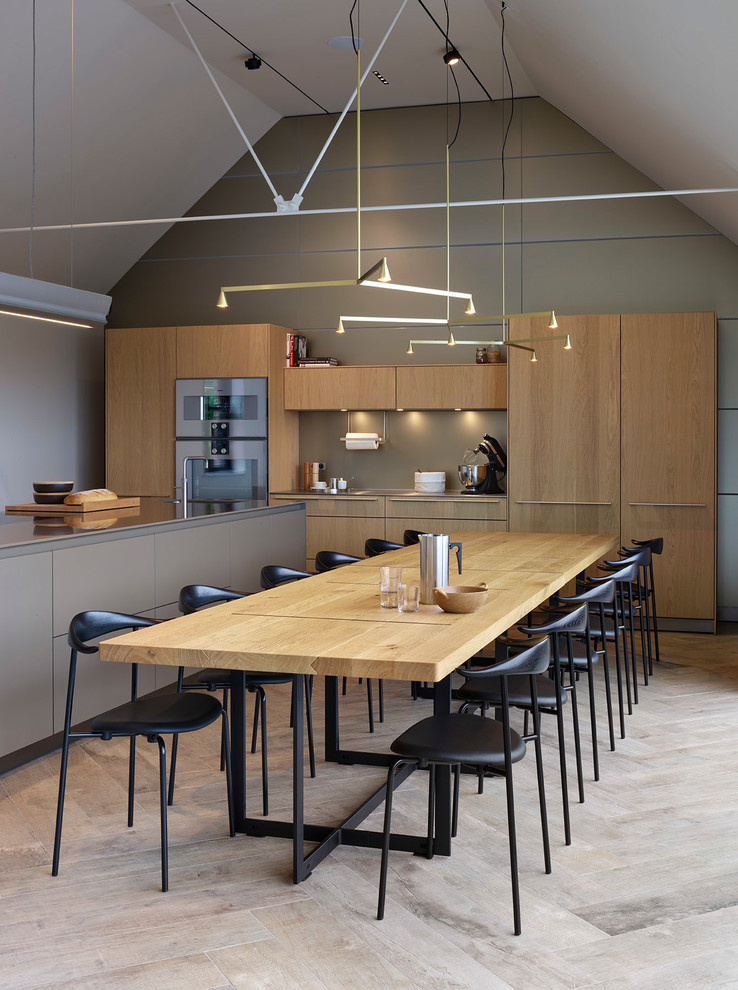 This is an example of a contemporary kitchen/dining combo in Manchester with grey walls and beige floor.
