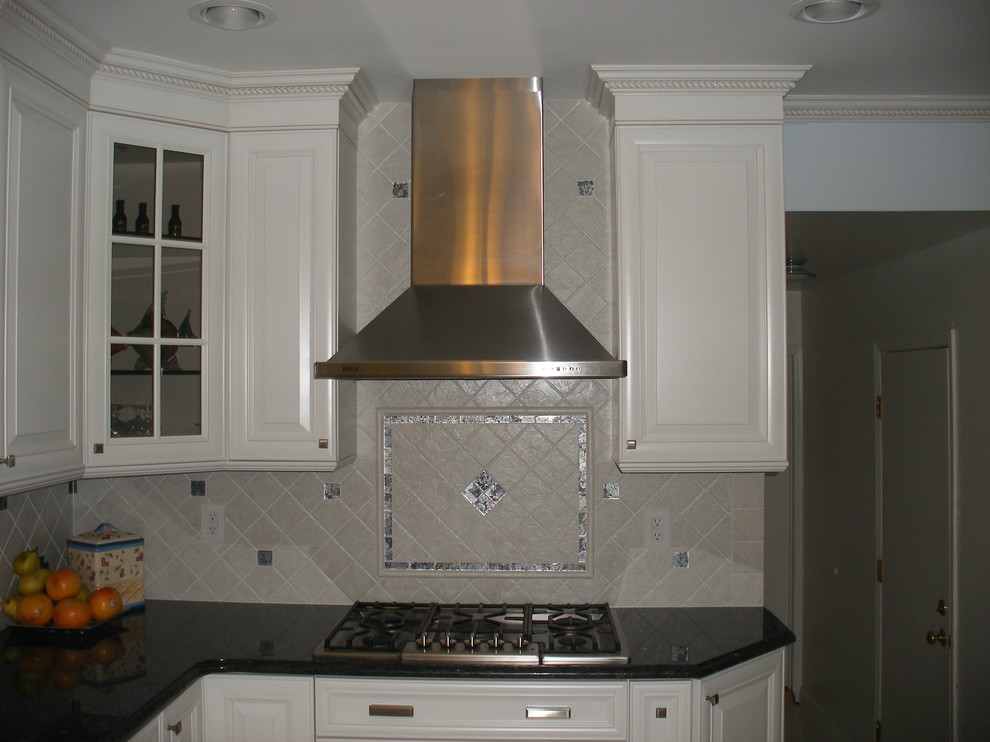 Inspiration for a mid-sized timeless l-shaped porcelain tile open concept kitchen remodel in New York with an undermount sink, raised-panel cabinets, white cabinets, quartz countertops, multicolored backsplash, mosaic tile backsplash and stainless steel appliances