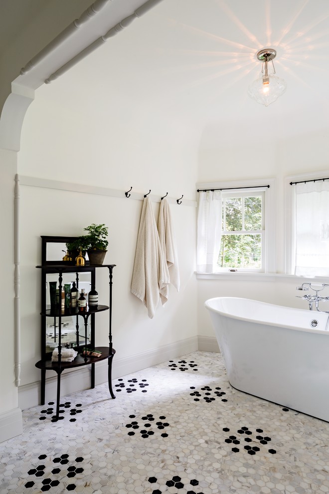 This is an example of a traditional bathroom in Portland with a freestanding tub, white walls and mosaic tile floors.
