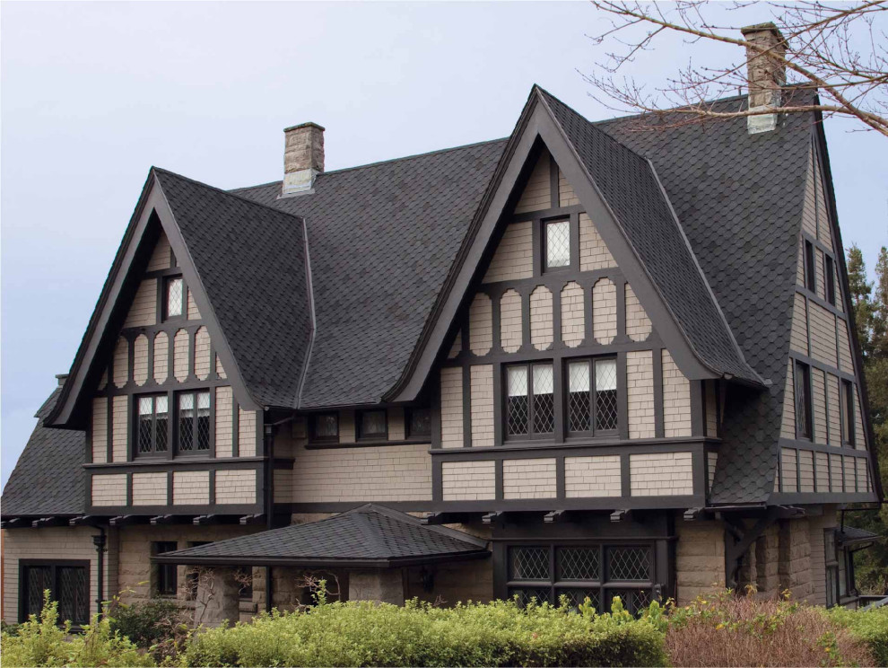 Ispirazione per la facciata di una casa con copertura a scandole e tetto nero