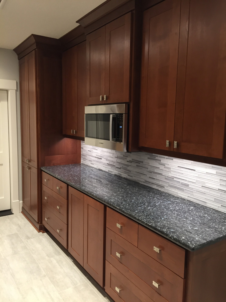 Inspiration for a large arts and crafts galley wet bar in Portland with an undermount sink, shaker cabinets, dark wood cabinets, granite benchtops, white splashback, ceramic splashback, ceramic floors, grey floor and blue benchtop.