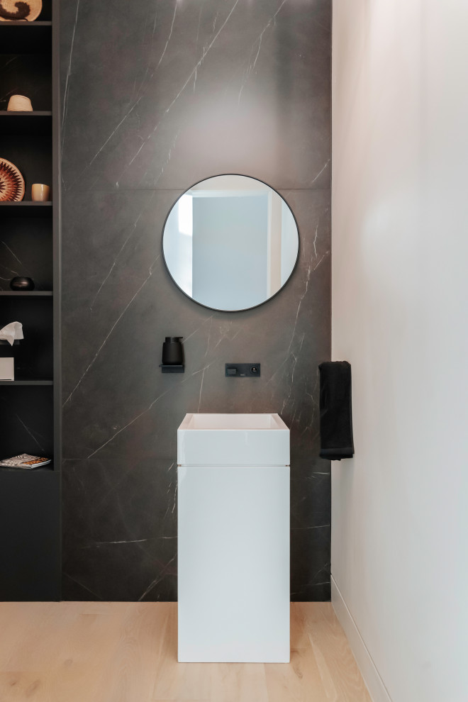 Inspiration for a mid-sized modern black tile and stone tile light wood floor and white floor powder room remodel in Phoenix with flat-panel cabinets, white cabinets, black walls, a pedestal sink, quartzite countertops, white countertops and a freestanding vanity