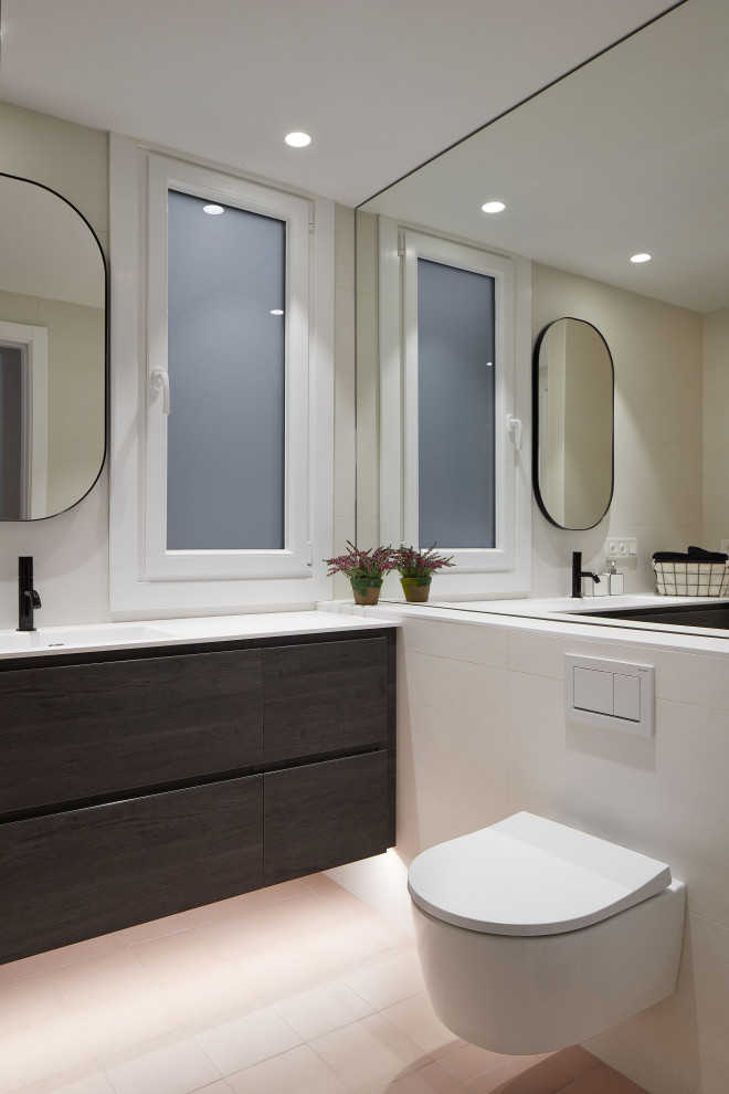 Inredning av ett modernt mellanstort vit vitt badrum med dusch, med släta luckor, vita skåp, en kantlös dusch, vit kakel, keramikplattor, bänkskiva i akrylsten, rosa golv och dusch med gångjärnsdörr