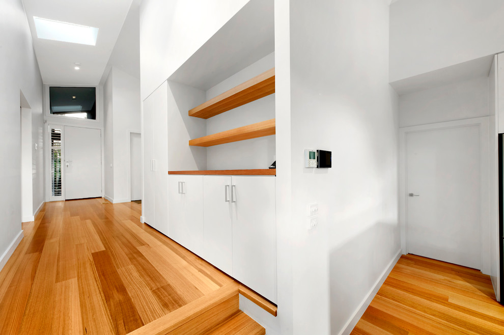 Design ideas for a large contemporary foyer in Melbourne with white walls, light hardwood floors, a single front door and a white front door.