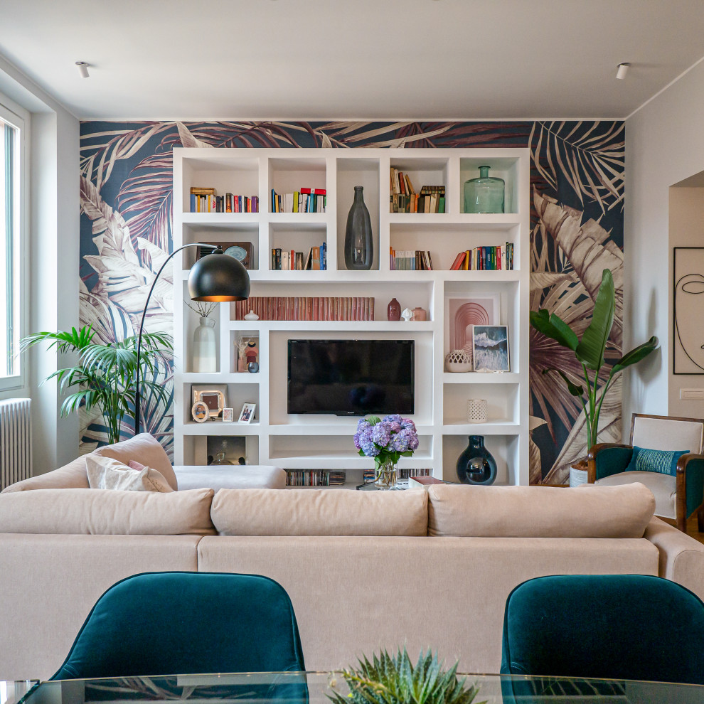 Imagen de salón abierto actual grande con paredes grises, suelo de madera clara, televisor colgado en la pared y papel pintado