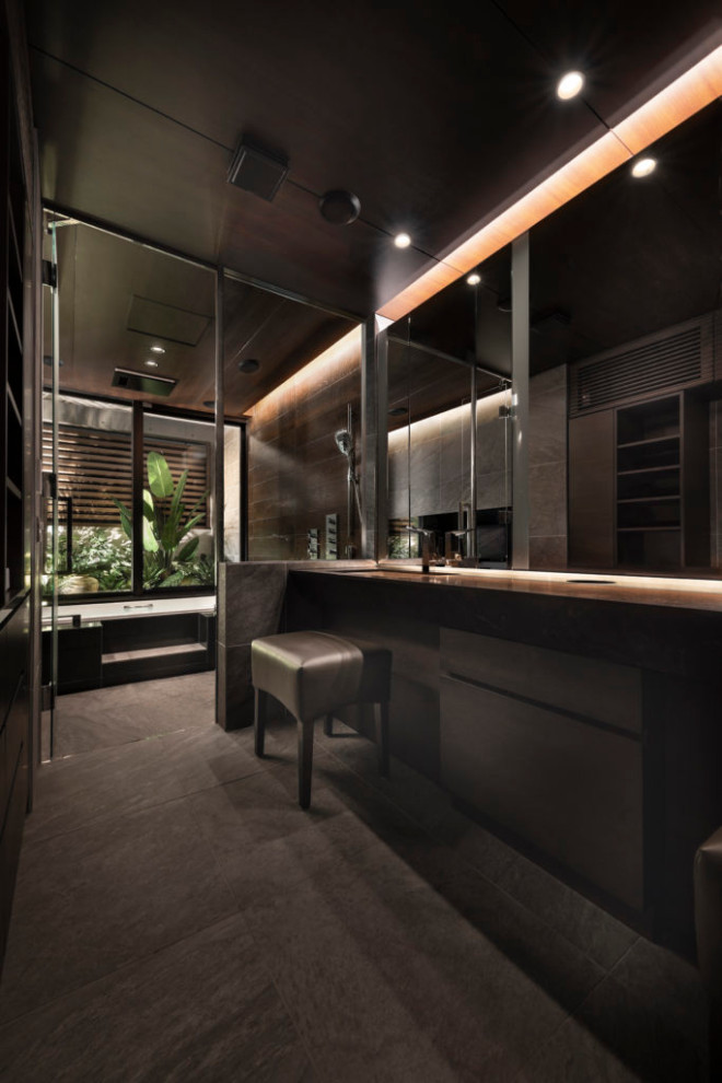 Diseño de cuarto de baño único y a medida moderno con bañera encastrada, baldosas y/o azulejos negros, paredes negras, lavabo bajoencimera, suelo negro y bandeja