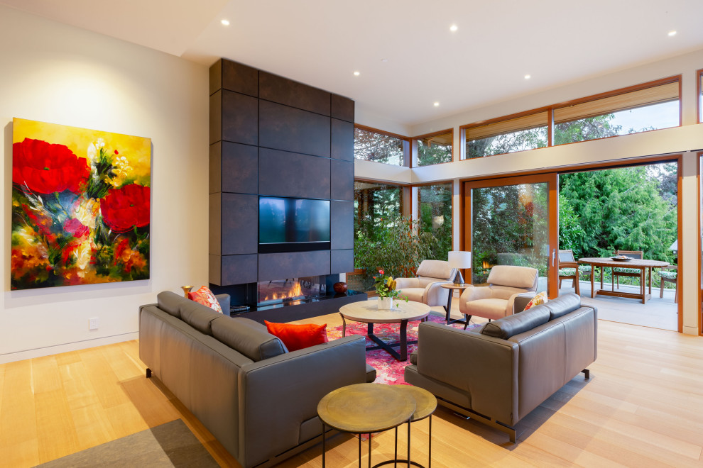 Large contemporary open concept living room in Vancouver with white walls, light hardwood floors, a ribbon fireplace, a tile fireplace surround, a built-in media wall and beige floor.