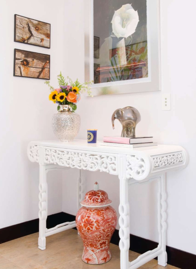 This is an example of a small eclectic vestibule in Miami with white walls and light hardwood floors.