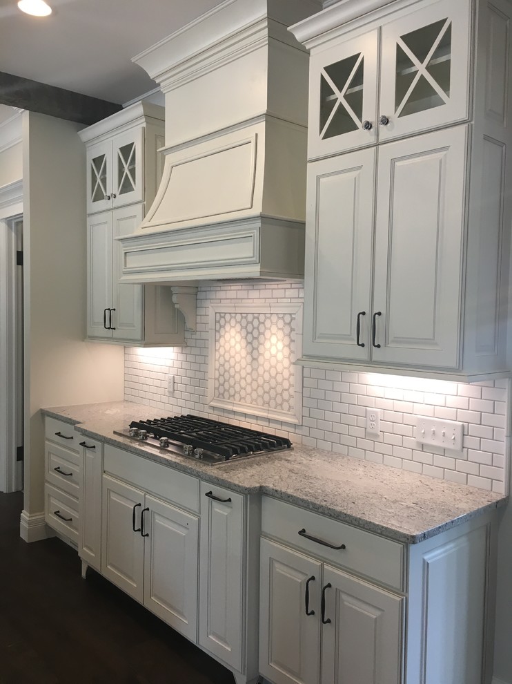 Mid-sized transitional galley separate kitchen in Nashville with raised-panel cabinets, white cabinets, quartzite benchtops, white splashback and subway tile splashback.