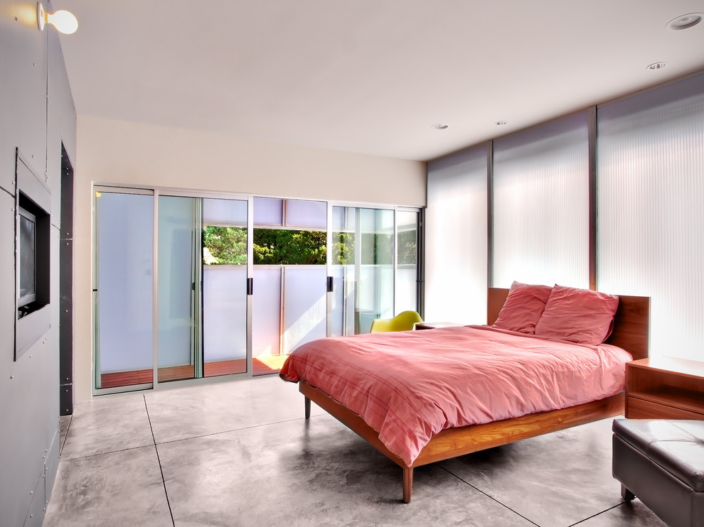 This is an example of a modern bedroom in Seattle with concrete floors.