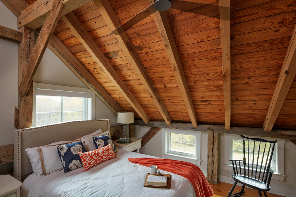 Esempio di una piccola camera degli ospiti country con pareti beige, pavimento in legno massello medio e pavimento marrone