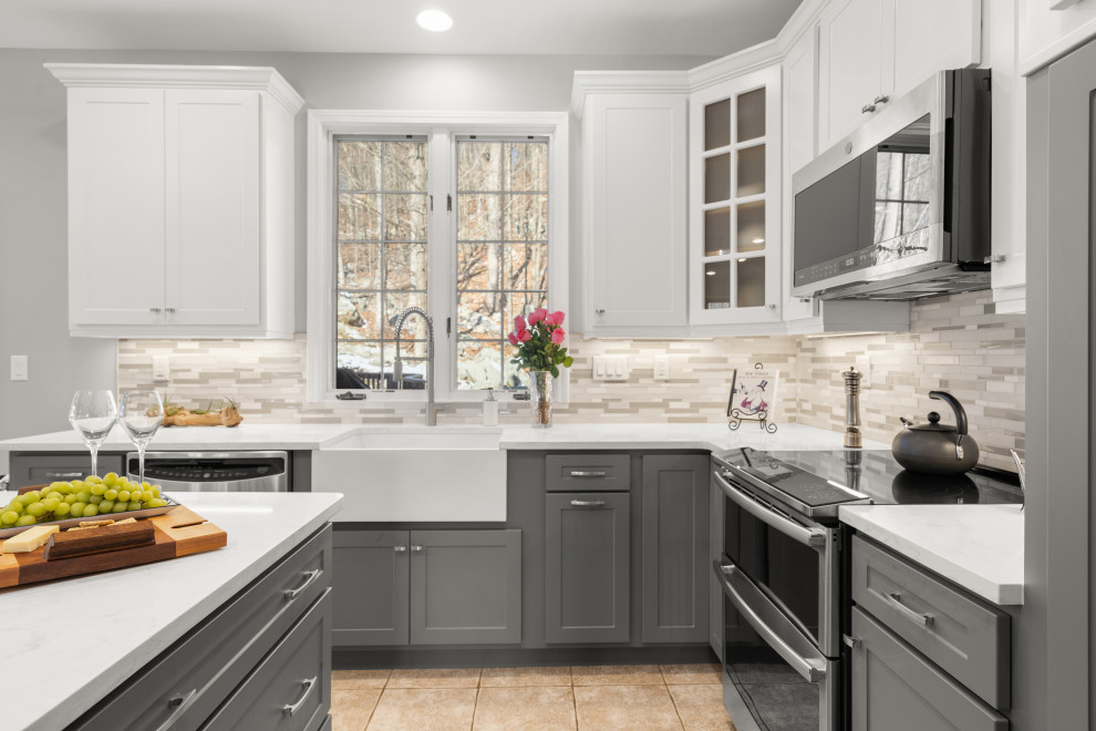 Inspiration for a large modern l-shaped porcelain tile and beige floor eat-in kitchen remodel in Philadelphia with a farmhouse sink, flat-panel cabinets, gray cabinets, quartz countertops, gray backsplash, mosaic tile backsplash, stainless steel appliances, an island and white countertops