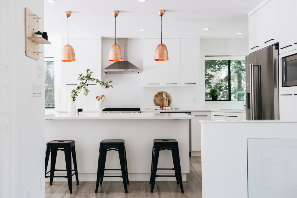 This is an example of a small modern l-shaped eat-in kitchen in Vancouver with an undermount sink, flat-panel cabinets, white cabinets, quartz benchtops, white splashback, ceramic splashback, stainless steel appliances, laminate floors, with island, grey floor, white benchtop and recessed.