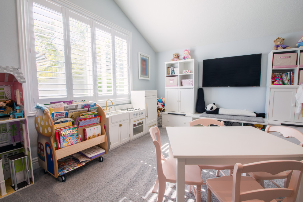 This is an example of a mid-sized contemporary kids' playroom for girls in Orange County with carpet and grey floor.