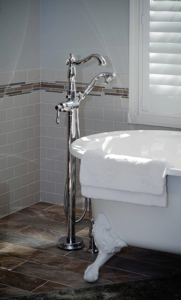 Design ideas for a large traditional master bathroom in Other with a claw-foot tub, a corner shower, beige tile, porcelain tile, blue walls, ceramic floors, an undermount sink, furniture-like cabinets, dark wood cabinets and brown floor.
