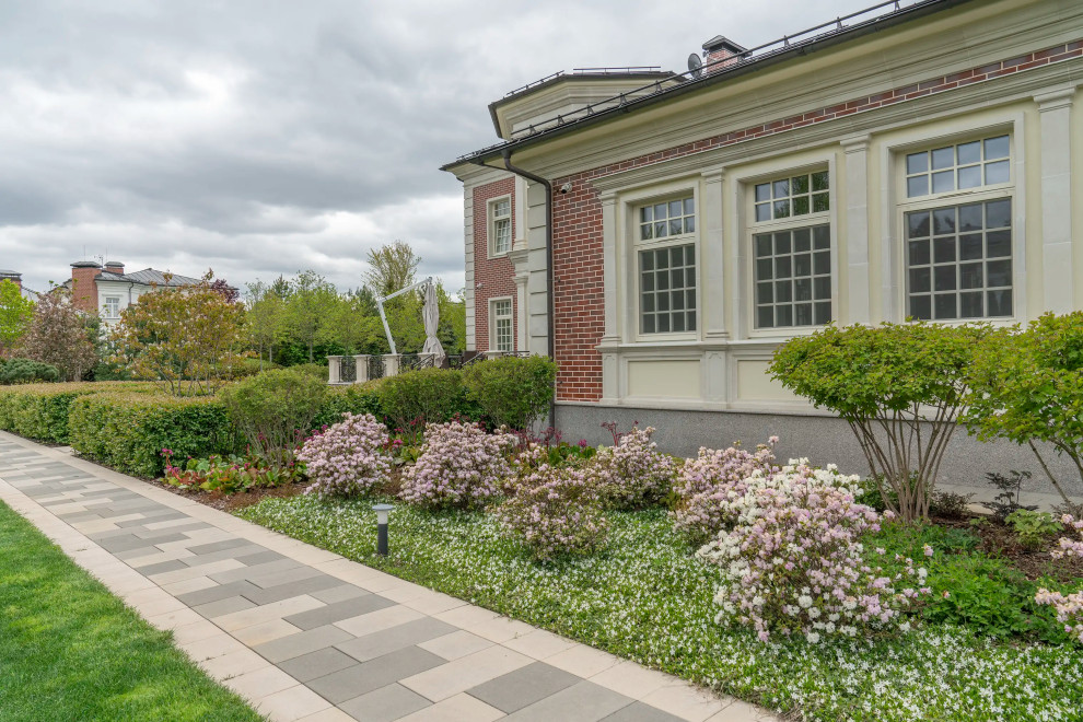Design ideas for a large transitional courtyard full sun formal garden for spring in Moscow with with a gate, concrete pavers and a metal fence.