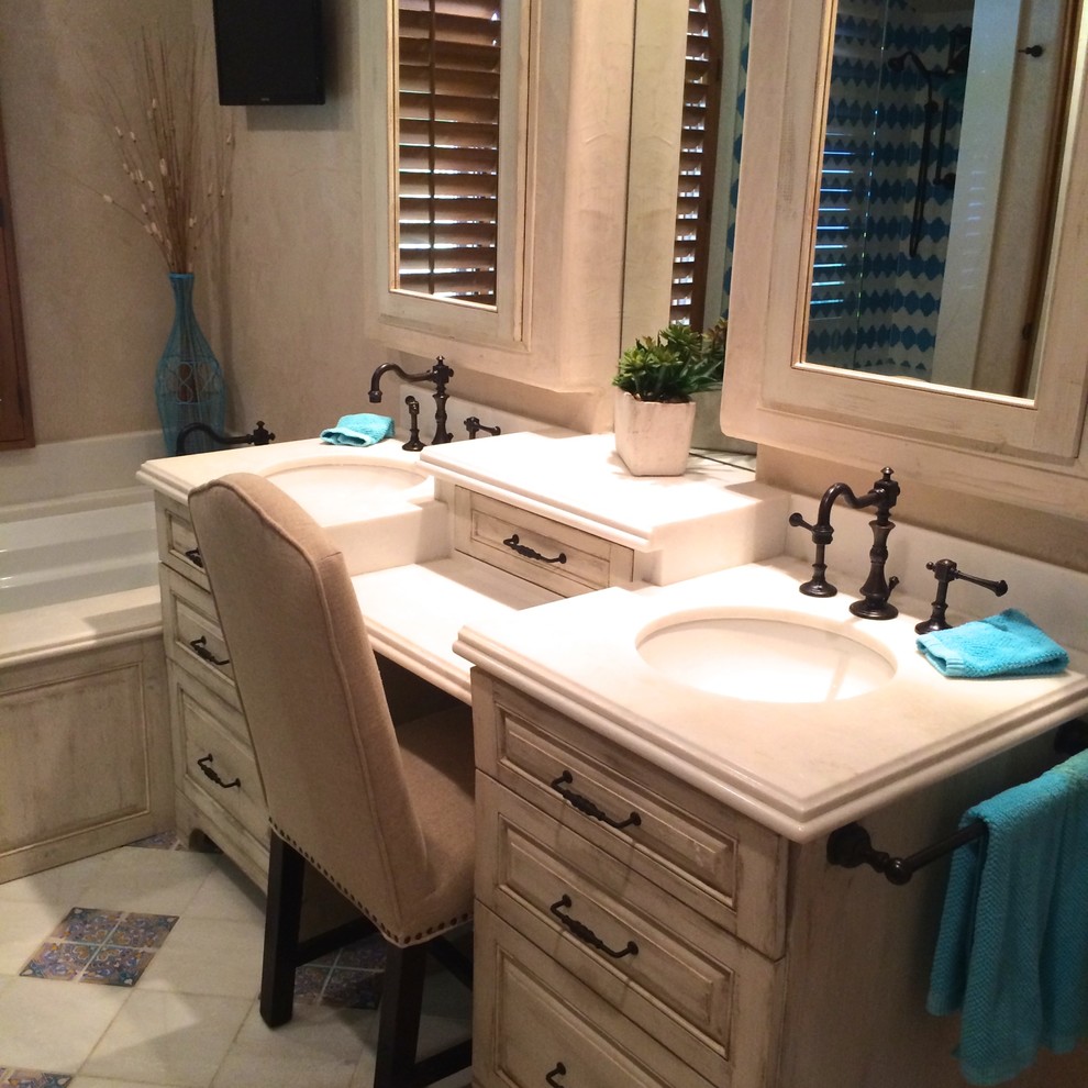 Mid-sized transitional master blue tile and porcelain tile ceramic tile and blue floor wet room photo with raised-panel cabinets, distressed cabinets, an undermount tub, beige walls, an undermount sink, solid surface countertops and a hinged shower door