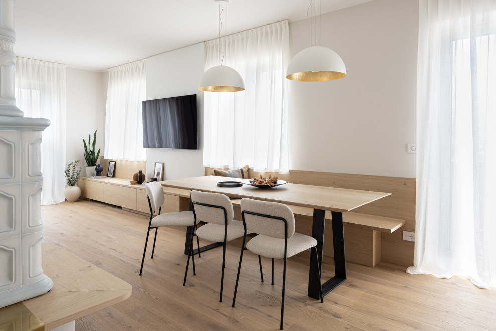 Ejemplo de comedor de cocina minimalista pequeño con paredes blancas, suelo de madera clara, estufa de leña y suelo marrón