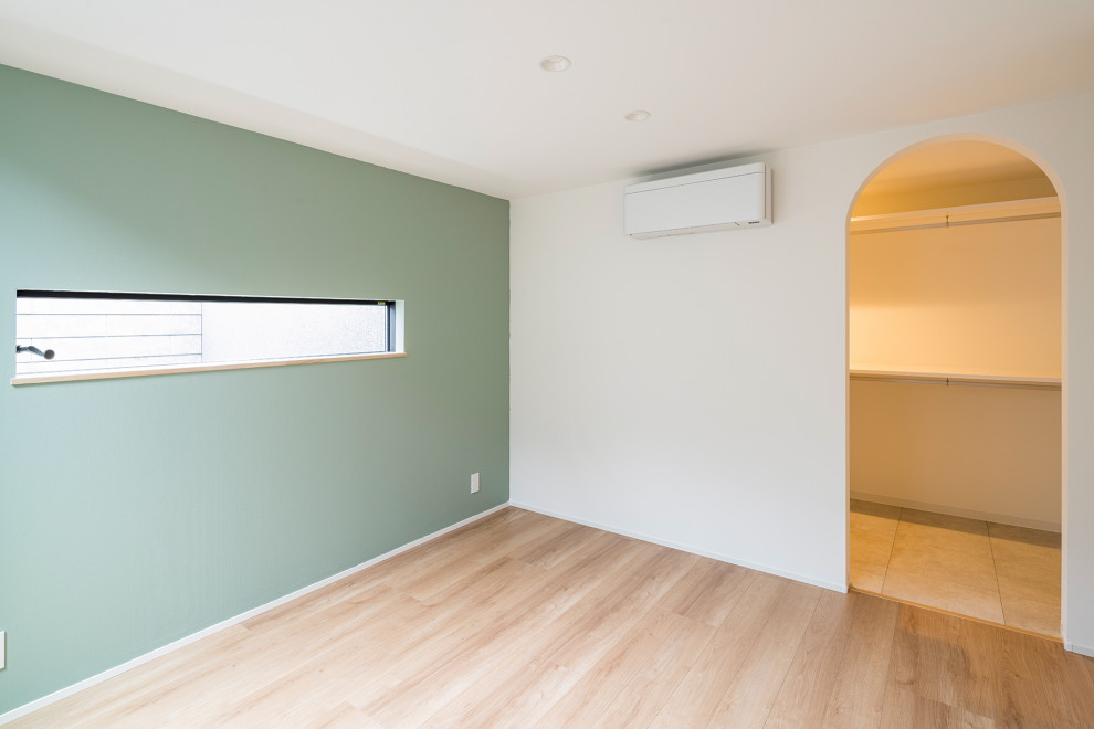 Foto de dormitorio principal contemporáneo de tamaño medio sin chimenea con paredes verdes, suelo de madera clara, suelo beige, papel pintado y papel pintado