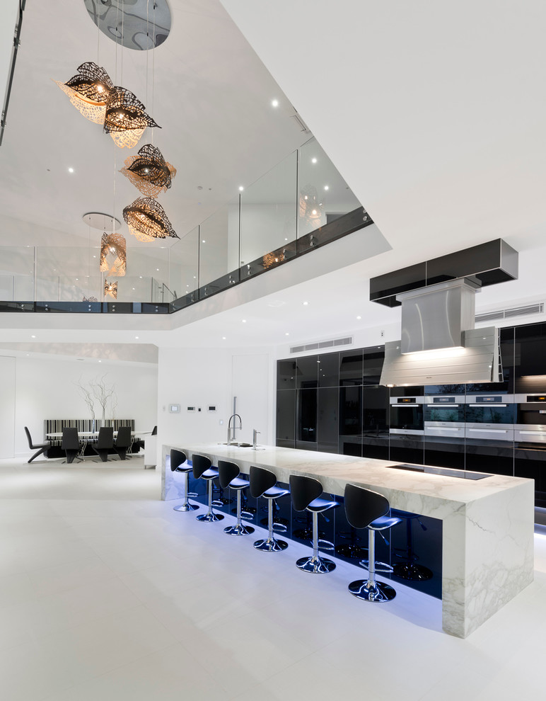 Expansive contemporary galley eat-in kitchen in Other with an undermount sink, flat-panel cabinets, marble benchtops, black splashback, glass sheet splashback, stainless steel appliances, ceramic floors and with island.
