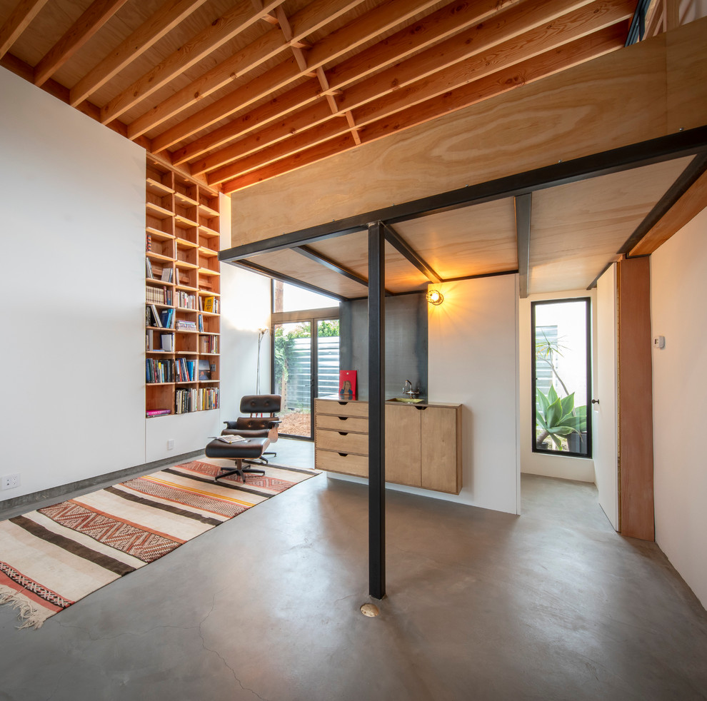This is an example of a modern home office in Los Angeles with white walls and concrete floors.