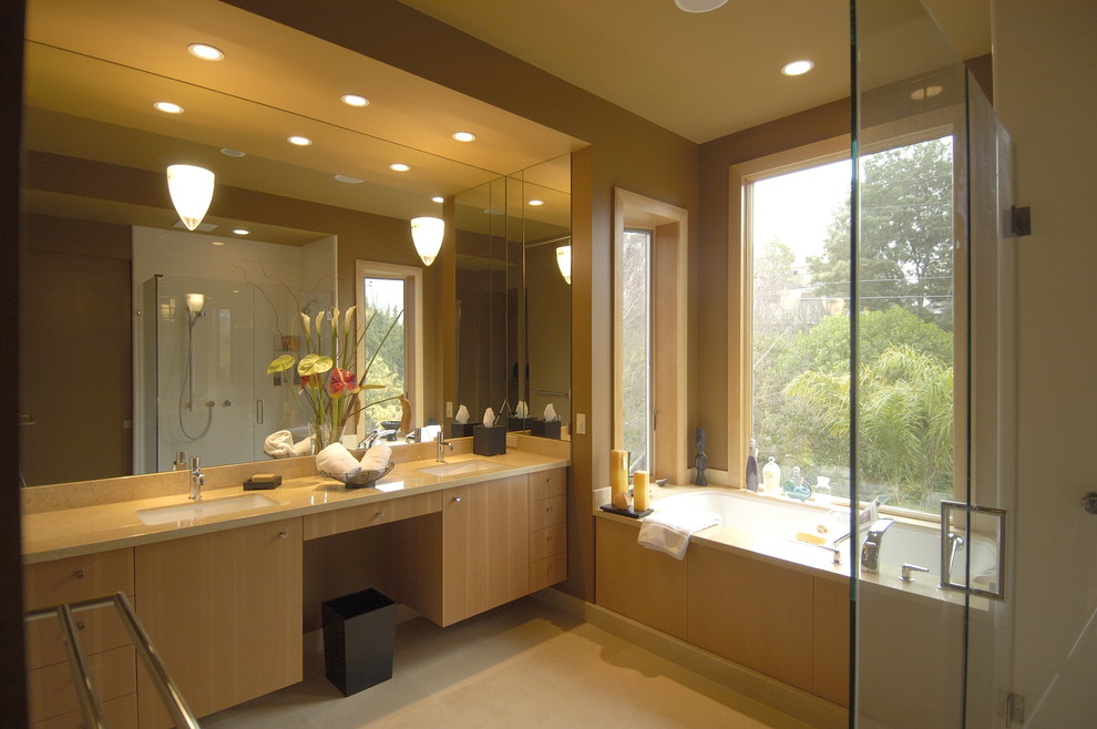 This is an example of a contemporary bathroom in San Francisco with an undermount sink, flat-panel cabinets, light wood cabinets, a corner shower and white tile.