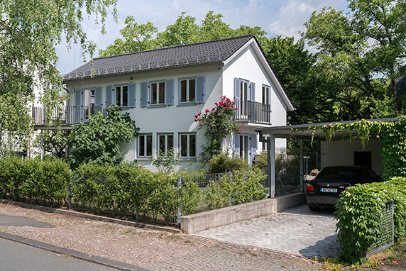 Photo of a mid-sized scandinavian two-storey concrete white exterior in Frankfurt with a gable roof.
