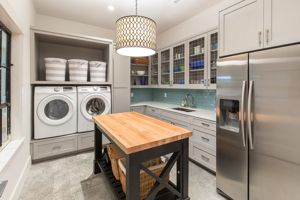 Design ideas for a transitional l-shaped utility room in Other with an undermount sink, shaker cabinets, grey cabinets, white walls, a side-by-side washer and dryer and grey floor.