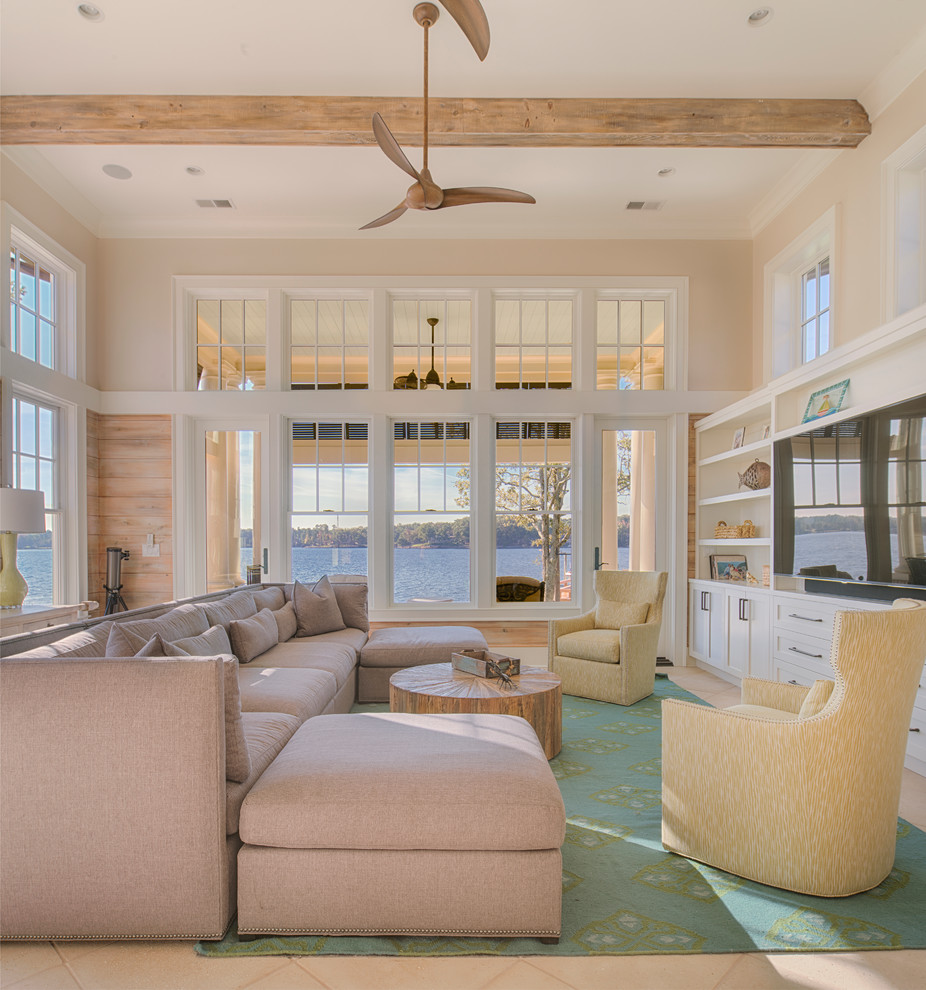 Beach style family room in Other with beige walls, a built-in media wall and beige floor.