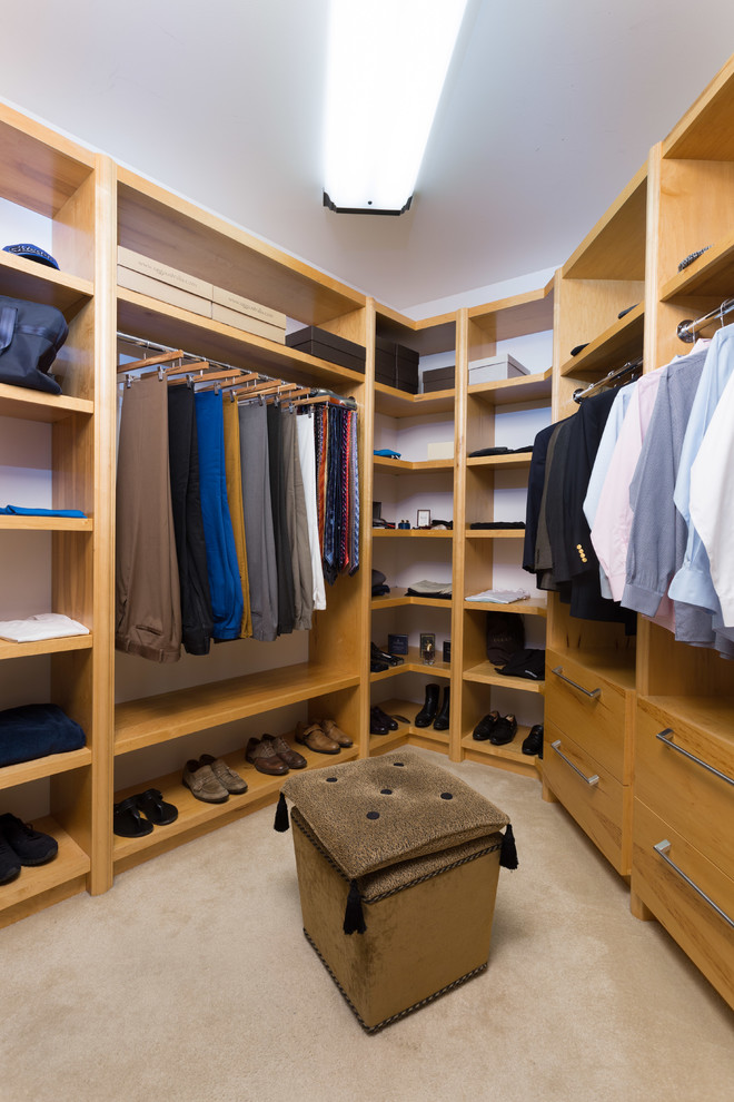 Photo of a mid-sized traditional men's dressing room in Chicago with open cabinets, light wood cabinets and carpet.
