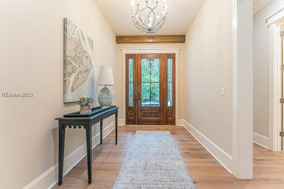 Inspiration for a mid-sized beach style foyer in Other with grey walls, medium hardwood floors, a single front door, a brown front door, brown floor and exposed beam.