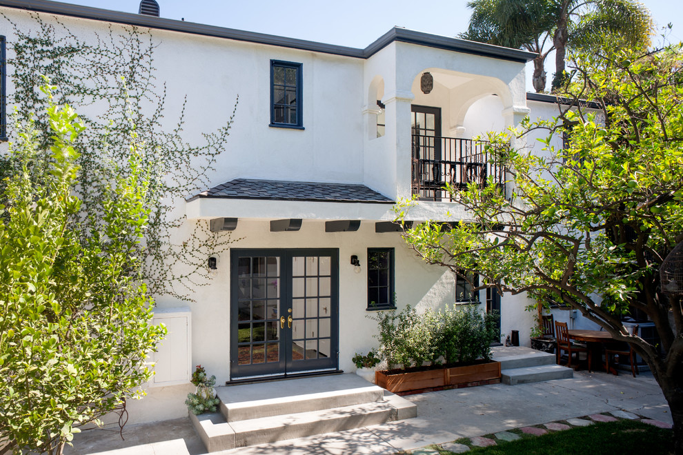 Inspiration for a large mediterranean two-storey stucco white exterior in Los Angeles with a hip roof.