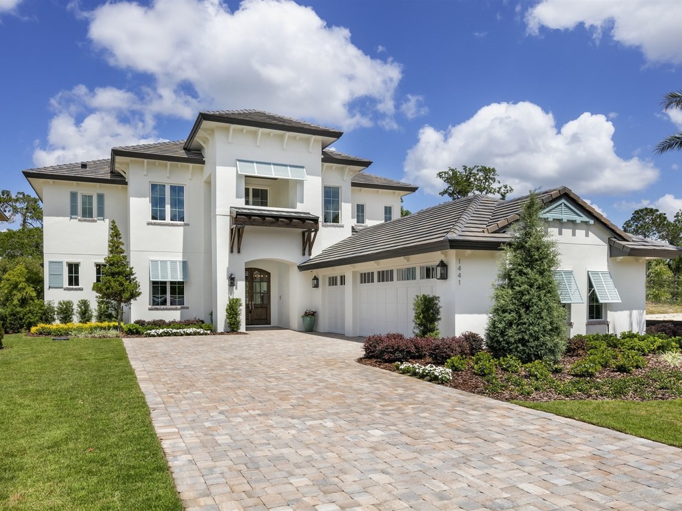 Large transitional two-storey stucco white house exterior in Orlando with a tile roof and a hip roof.