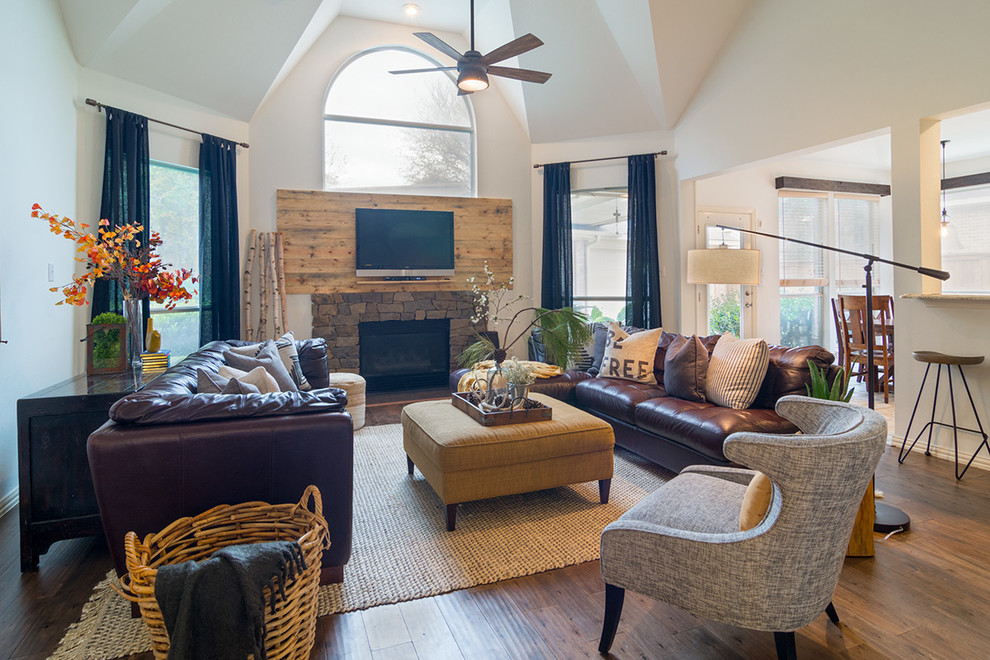 Design ideas for a large country open concept family room in Dallas with white walls, dark hardwood floors, a stone fireplace surround and a wall-mounted tv.