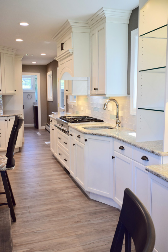 Eat-in kitchen - huge transitional vinyl floor and brown floor eat-in kitchen idea with a farmhouse sink, recessed-panel cabinets, white cabinets, quartz countertops, multicolored backsplash, ceramic backsplash, stainless steel appliances, an island and multicolored countertops