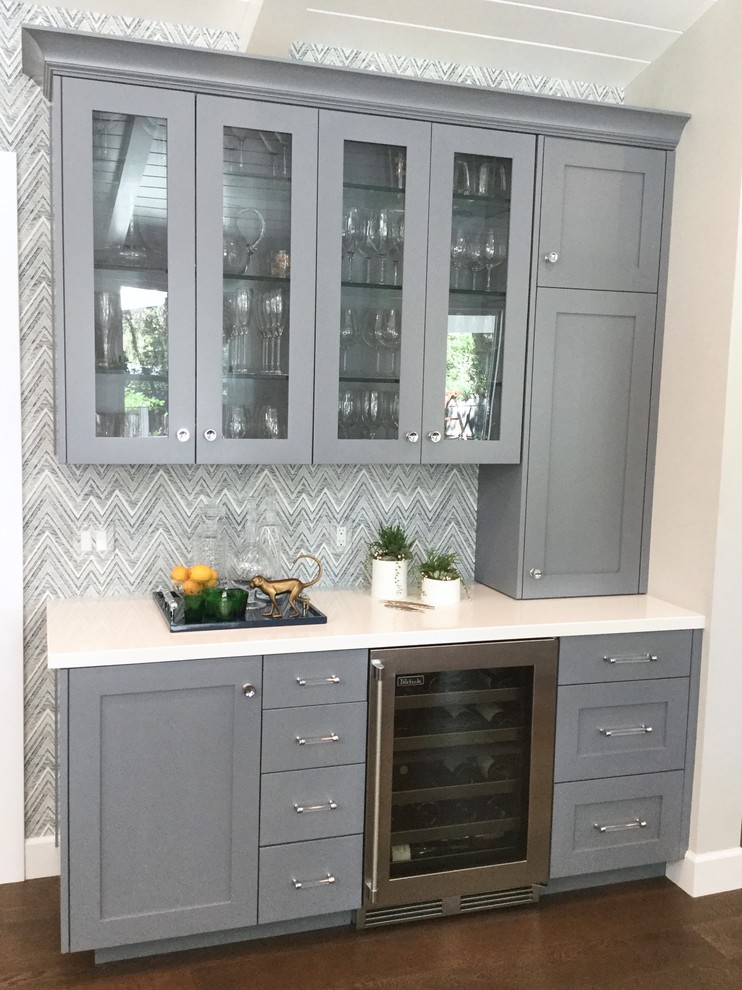 Inspiration for a mid-sized transitional single-wall wet bar in San Francisco with no sink, shaker cabinets, grey cabinets, quartz benchtops, white splashback, dark hardwood floors, brown floor and white benchtop.