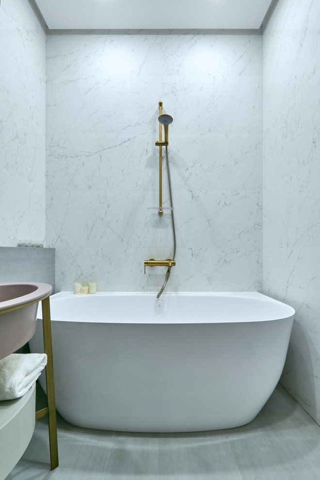This is an example of a small contemporary master bathroom in Moscow with flat-panel cabinets, white cabinets, a freestanding tub, a shower/bathtub combo, white tile, pink tile, gray tile, porcelain floors, an integrated sink, grey floor, a double vanity, a freestanding vanity, a wall-mount toilet and porcelain tile.