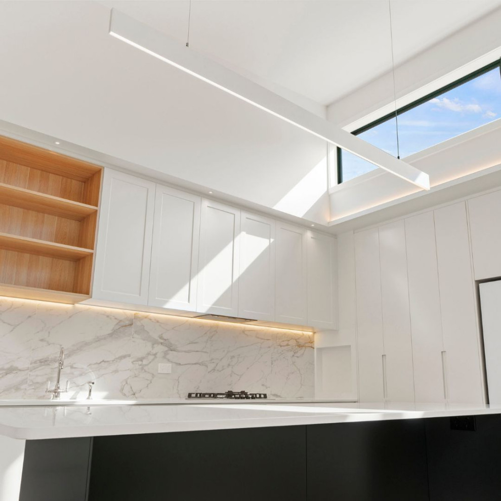 Exempel på ett avskilt, litet modernt kök, med vita skåp, vitt stänkskydd, stänkskydd i marmor och en köksö