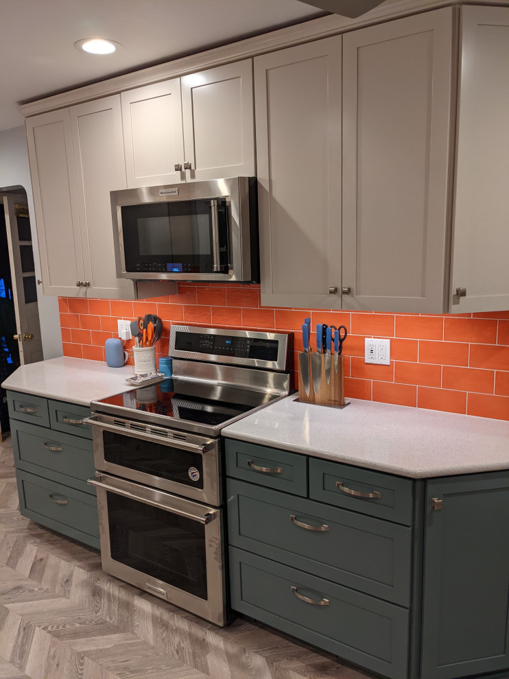 シカゴにある高級な中くらいなモダンスタイルのおしゃれなキッチン (アンダーカウンターシンク、シェーカースタイル扉のキャビネット、グレーのキャビネット、オレンジのキッチンパネル、ガラスタイルのキッチンパネル、シルバーの調理設備、磁器タイルの床、アイランドなし、グレーの床、白いキッチンカウンター) の写真