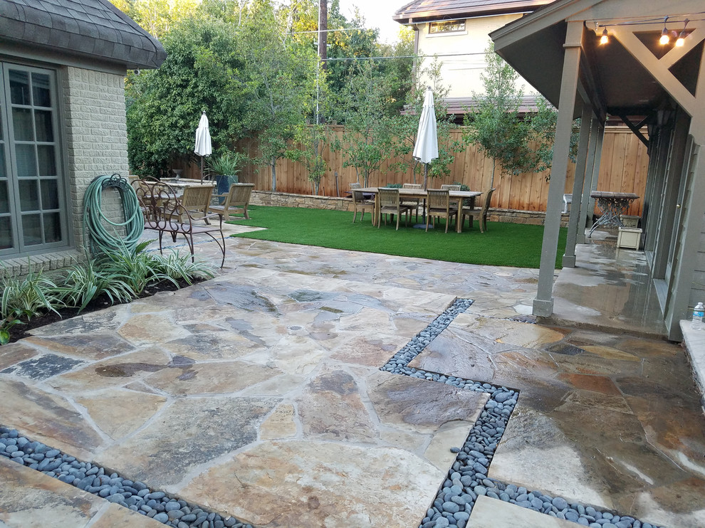 This is an example of a mid-sized traditional backyard partial sun formal garden for summer in Dallas with a container garden and natural stone pavers.