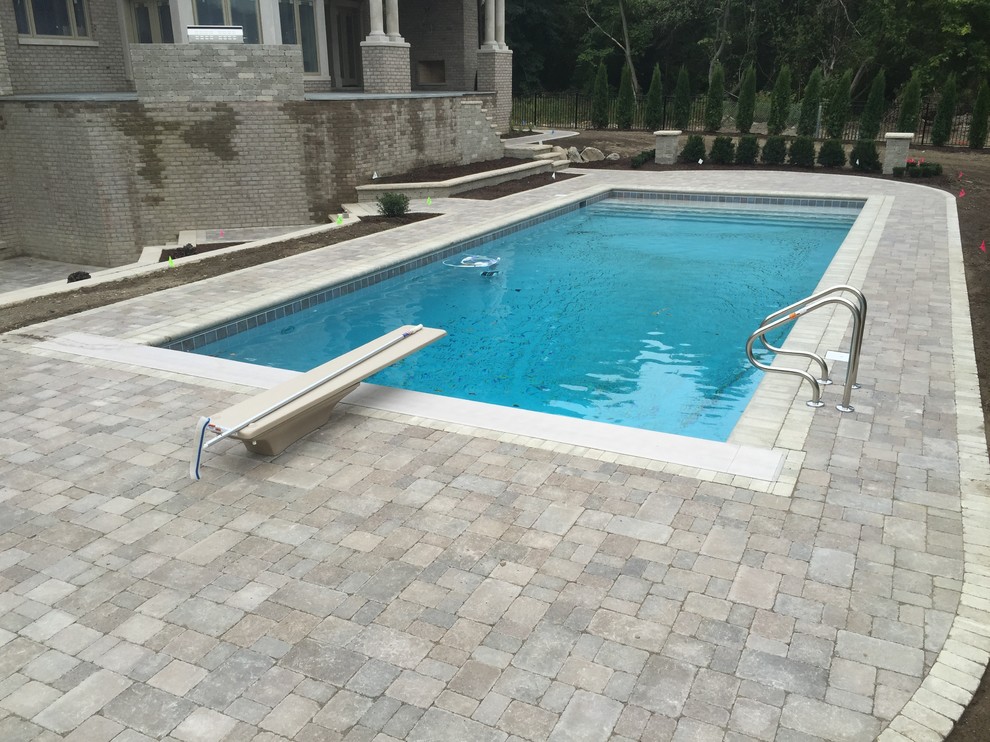 Inspiration for a mediterranean backyard custom-shaped pool in Detroit with a hot tub and brick pavers.