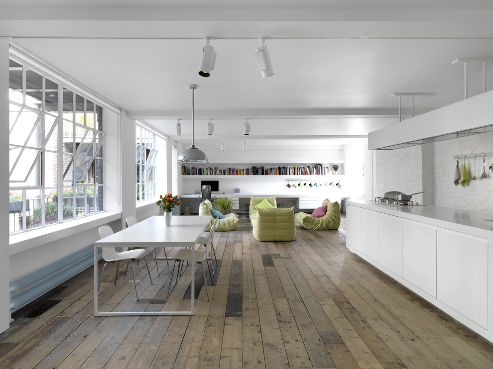 Photo of a large industrial open plan dining in Milan with white walls, light hardwood floors and no fireplace.