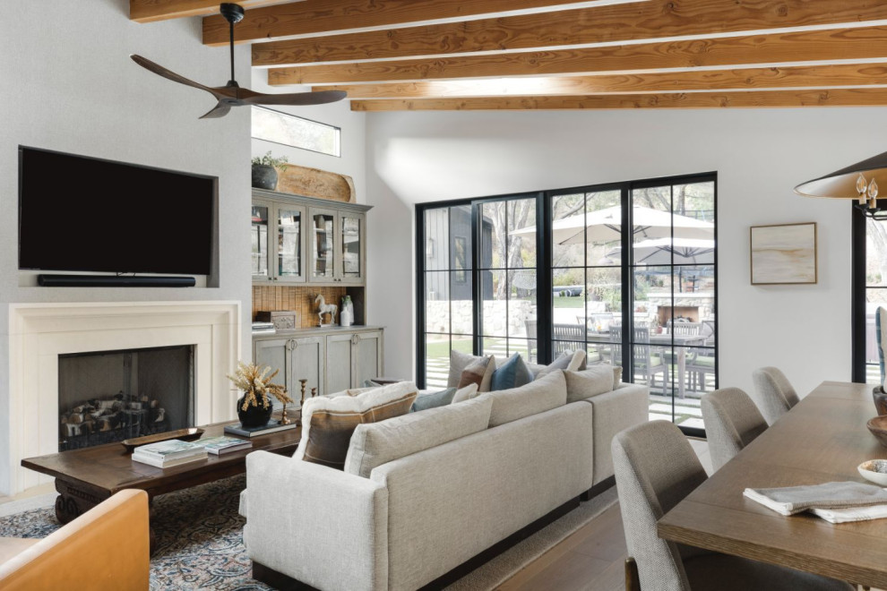 Photo of a mid-sized contemporary formal open concept living room in Los Angeles with white walls, medium hardwood floors, a standard fireplace, a concrete fireplace surround and a wall-mounted tv.