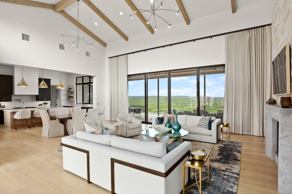 Inspiration for a large transitional formal enclosed living room in Austin with white walls, light hardwood floors, a standard fireplace, a stone fireplace surround, a built-in media wall, beige floor and vaulted.