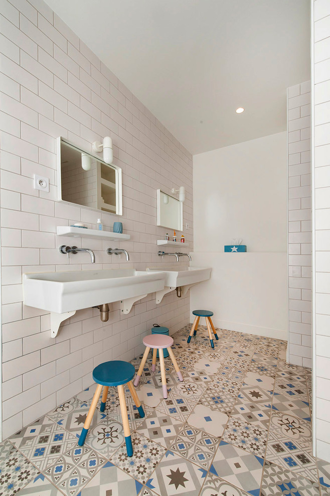 Photo of a small scandinavian kids bathroom in Paris with white cabinets, an undermount tub, white walls, a trough sink, an open shower, white benchtops, cement tiles, blue floor, a wall-mount toilet, white tile and subway tile.