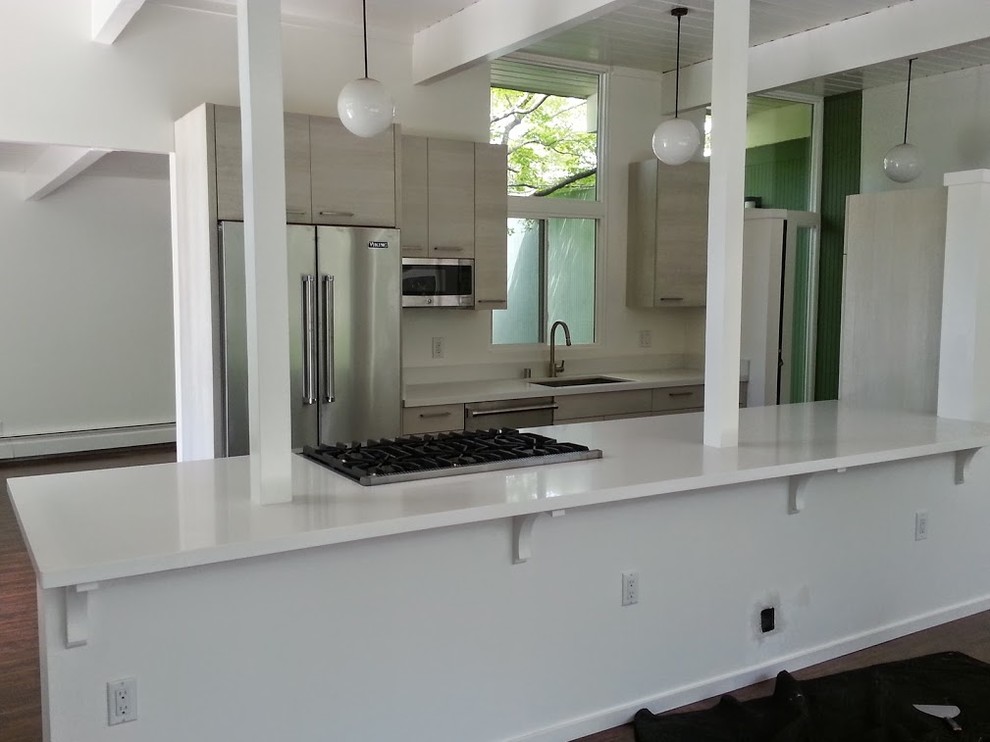 Photo of a mid-sized contemporary l-shaped open plan kitchen in San Francisco with an undermount sink, flat-panel cabinets, quartz benchtops, stainless steel appliances and a peninsula.