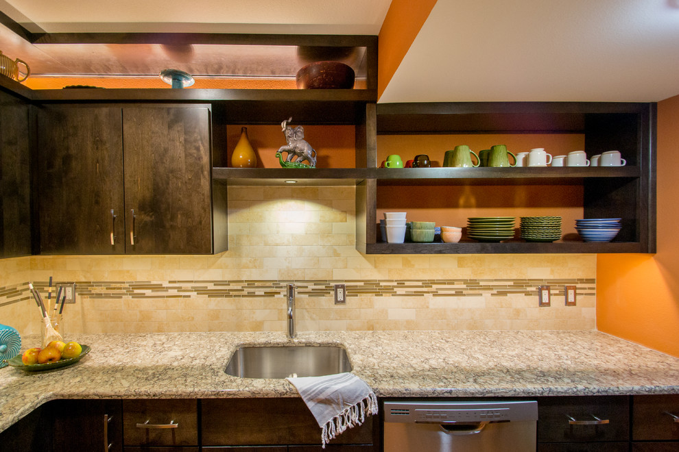 Inspiration for a mid-sized modern l-shaped enclosed kitchen remodel in Cedar Rapids with an undermount sink, flat-panel cabinets, dark wood cabinets, beige backsplash, stainless steel appliances, granite countertops, subway tile backsplash and gray countertops