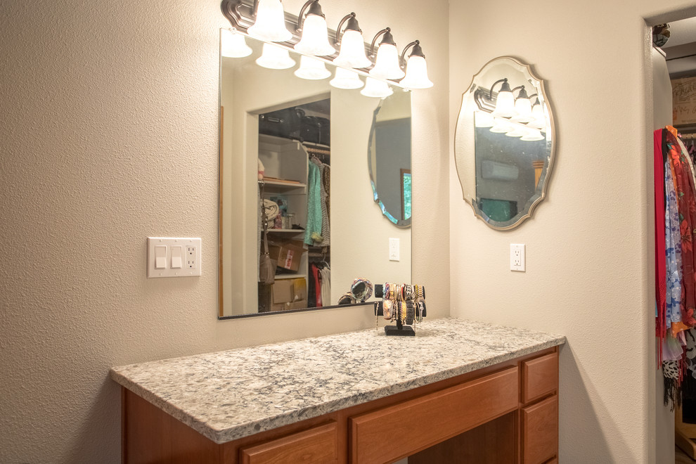 This is an example of a traditional women's dressing room in Portland with flat-panel cabinets, medium wood cabinets, vinyl floors and beige floor.